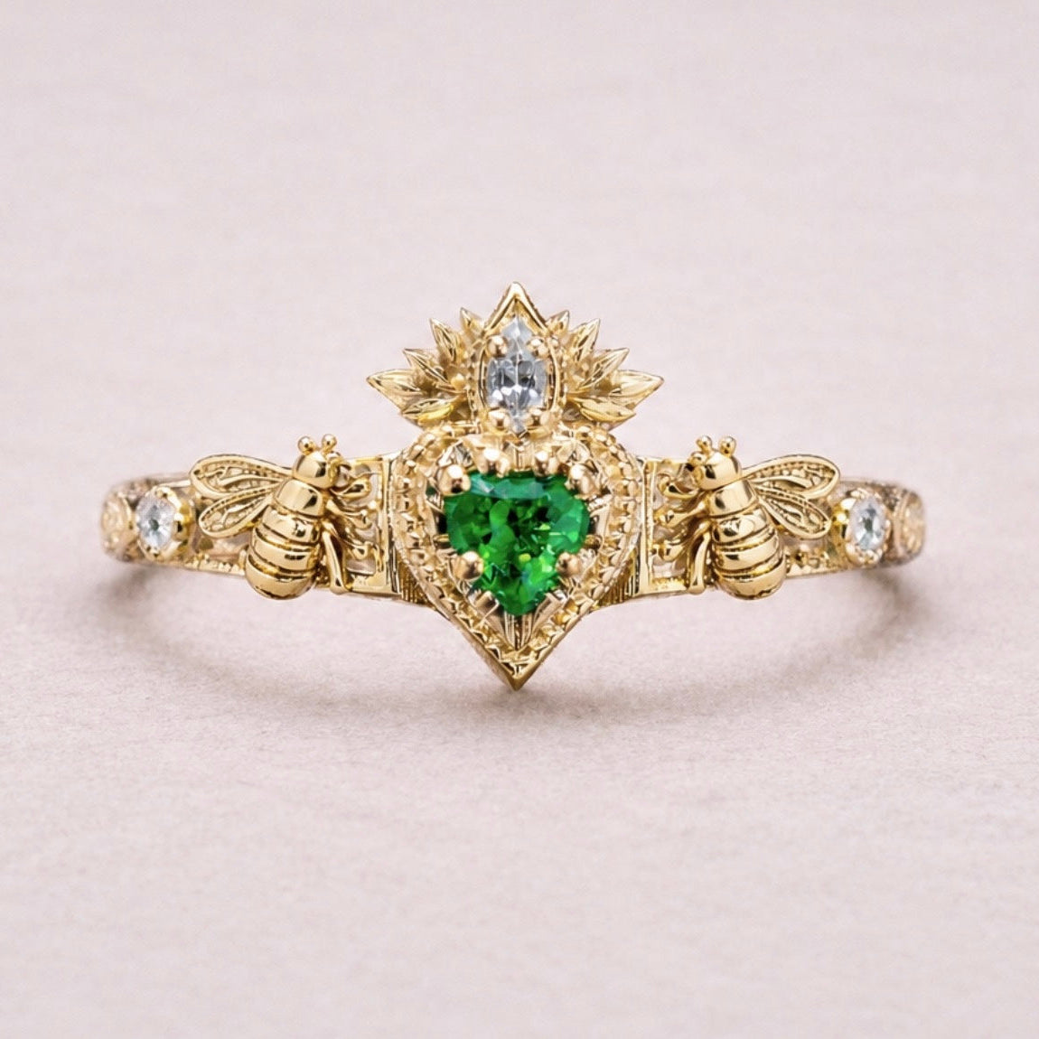 Gold ring with a green gemstone and bee designs