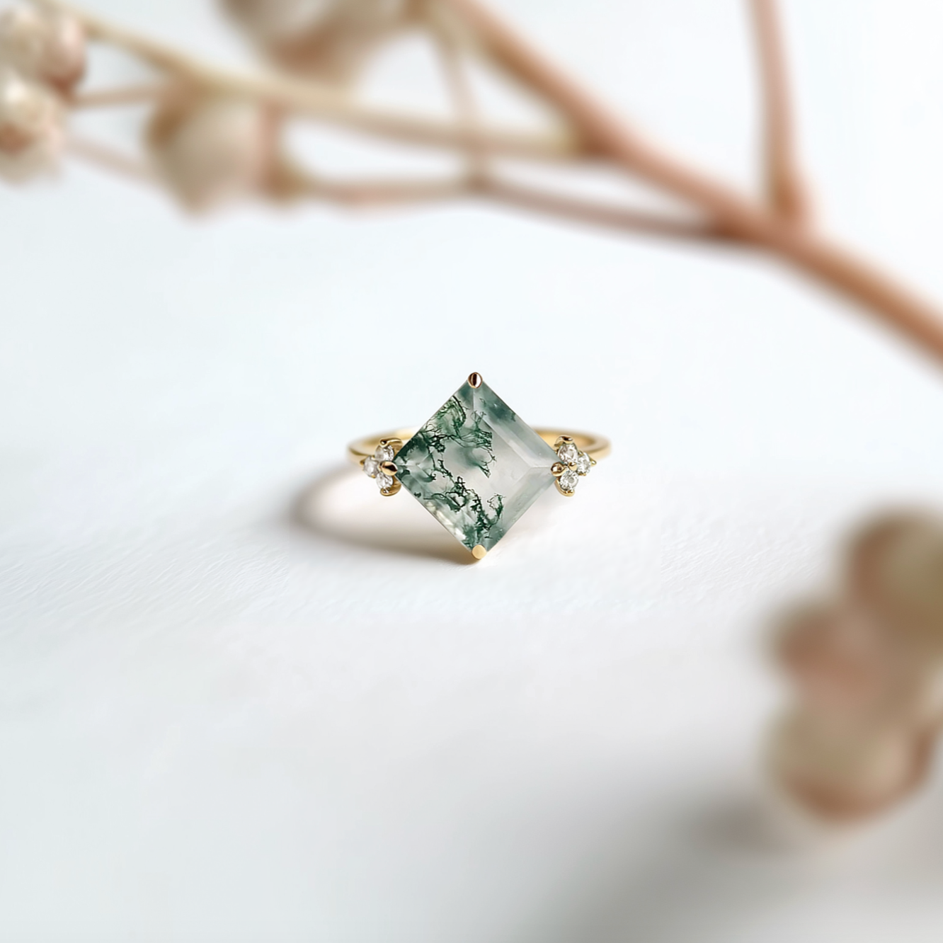 Gold ring with a green gemstone on a light background