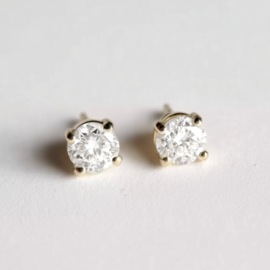 Pair of diamond stud earrings on a light gray background