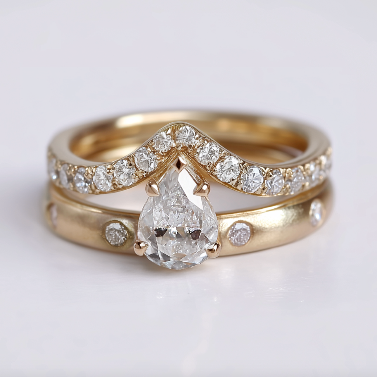 Gold ring with a pear-shaped diamond on a light background