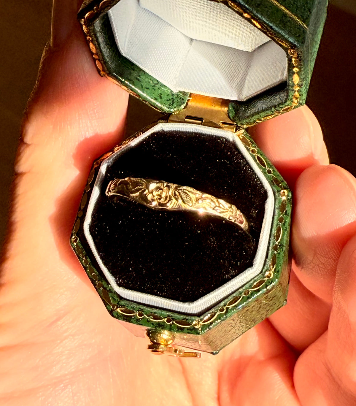 Close-up of floral leaf engraving on yellow gold wedding band