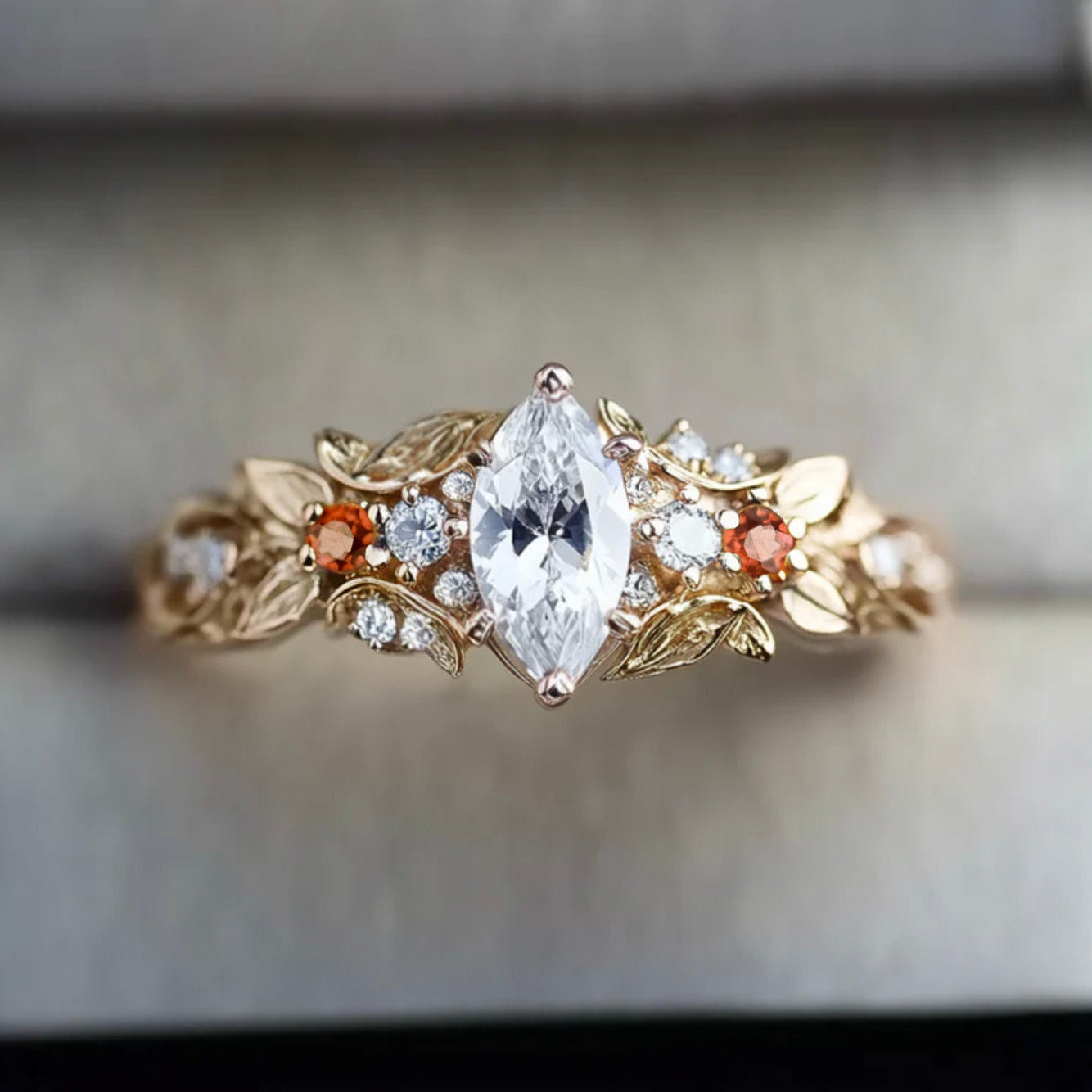 Gold ring with diamond and leaf design on a neutral background