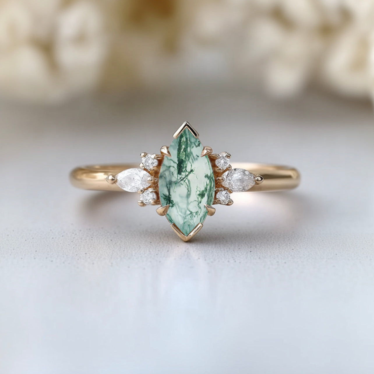Gold ring with a green gemstone and small diamonds on a light background
