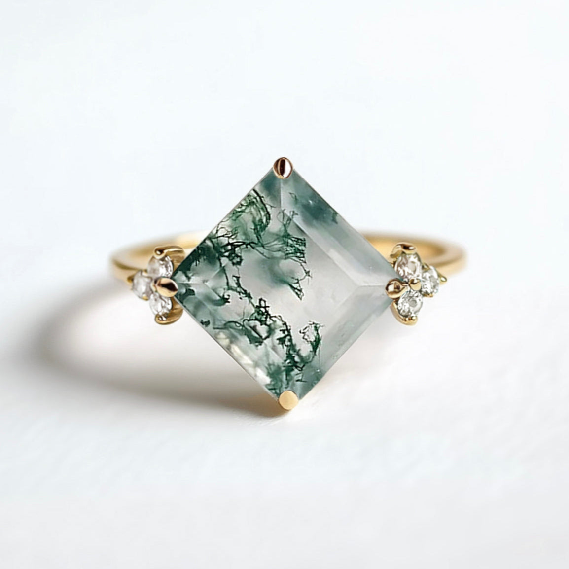 Ring with a green gemstone and gold accents on a white background
