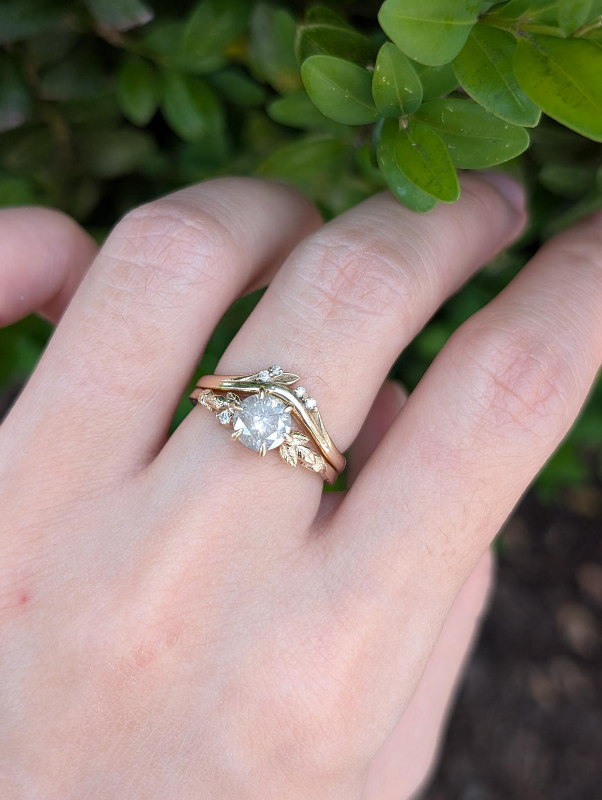 Yellow gold salt and pepper diamond ring with matching wedding band shown on hand