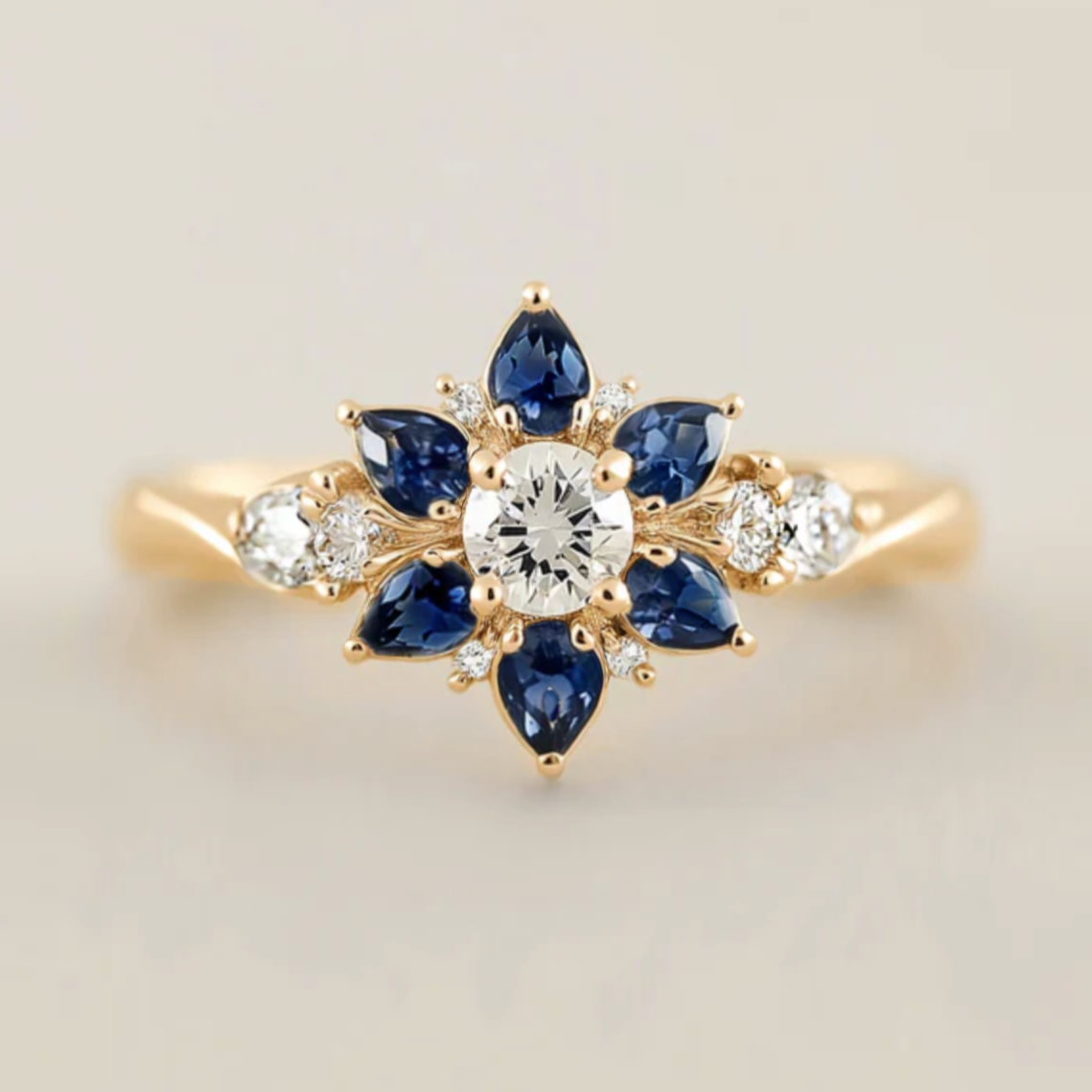 Gold ring with blue gemstones and diamonds on a light background