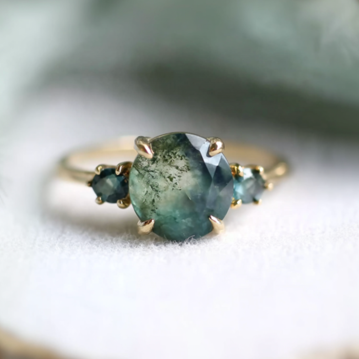 Gold ring with a green gemstone on a soft background