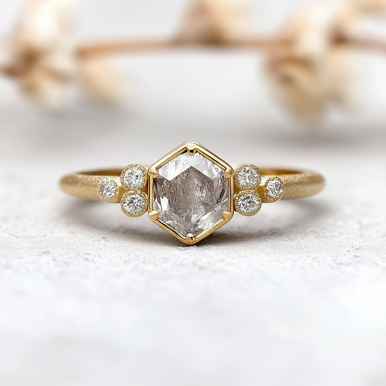Gold ring with a central diamond and smaller diamonds on a light background