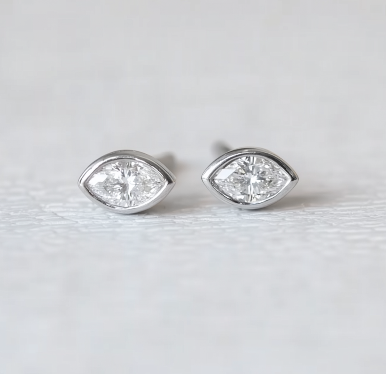 Pair of diamond stud earrings on a light gray background