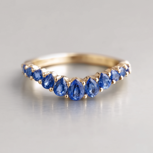 Gold ring with blue sapphire on a gray background
