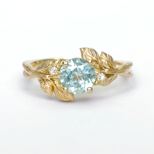 Gold ring with a blue gemstone on a white background