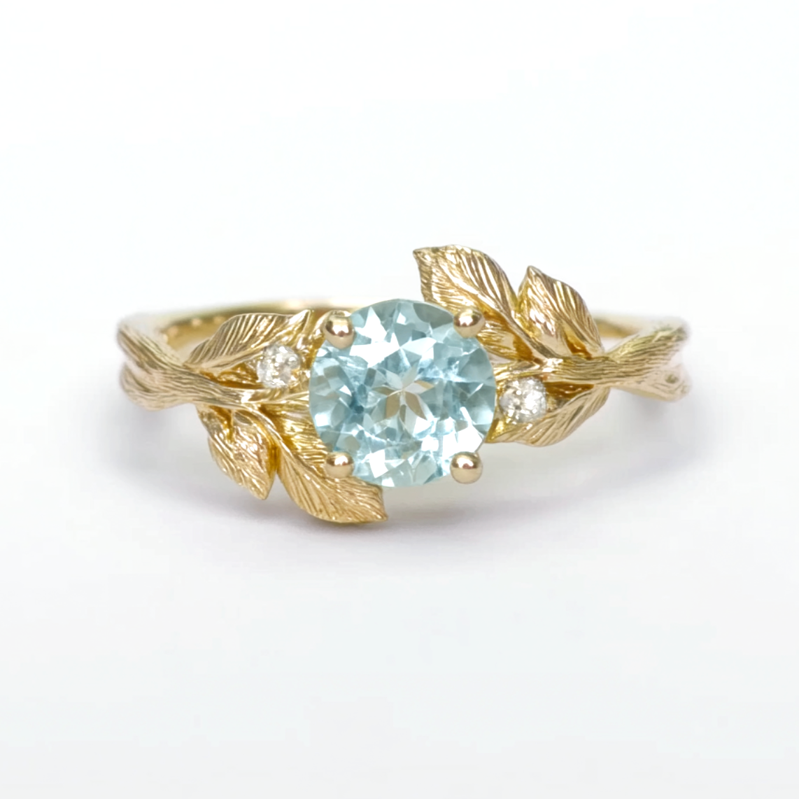 Gold ring with a blue gemstone on a white background