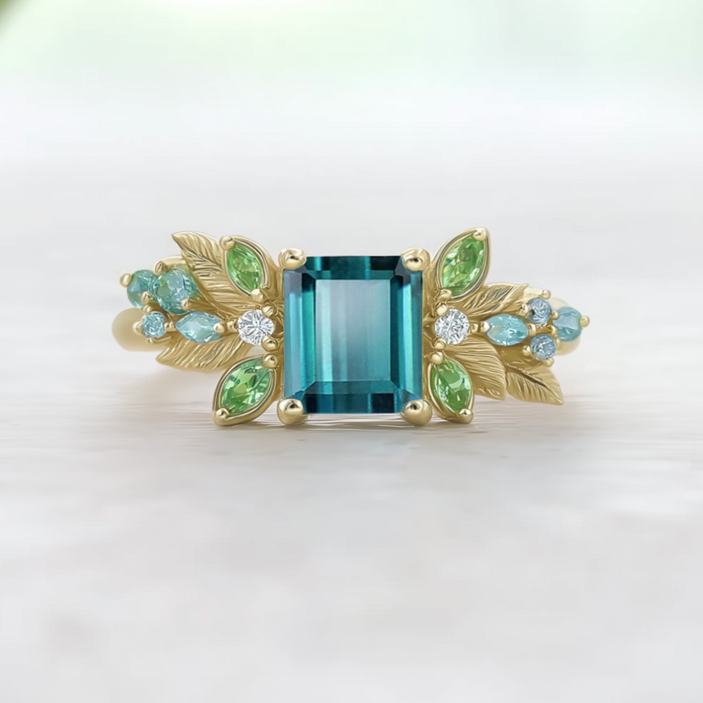 Gold ring with a blue tourmaline and green accent birthstone on the shank 