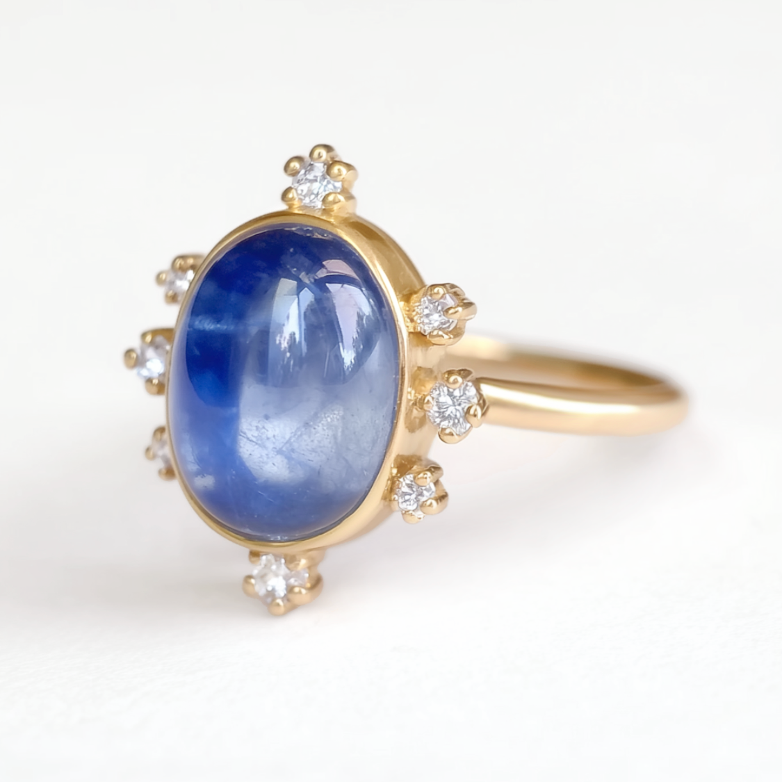Gold ring with a blue sapphire and small diamonds on a white background
