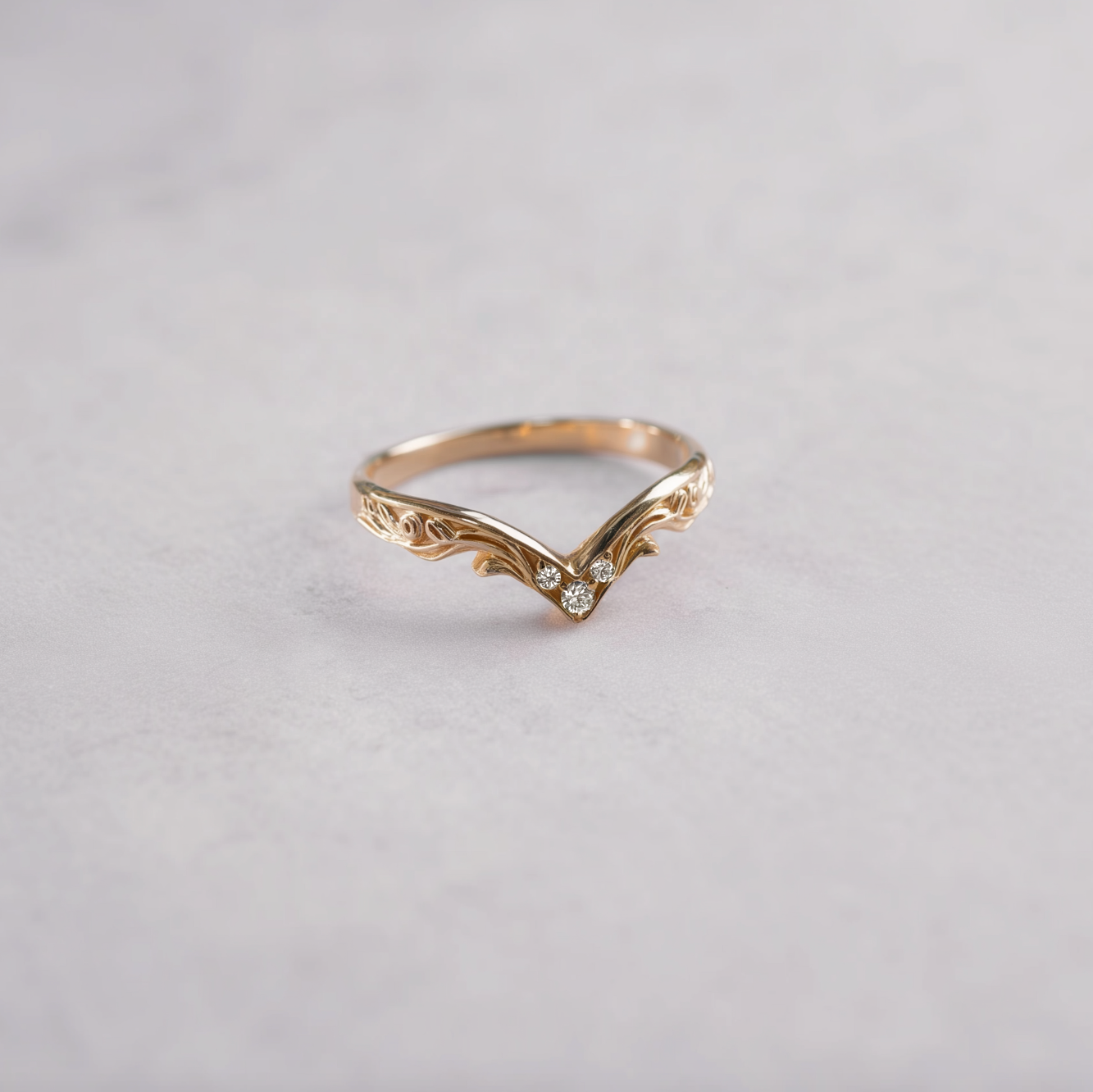 Gold ring with diamond on a light gray background