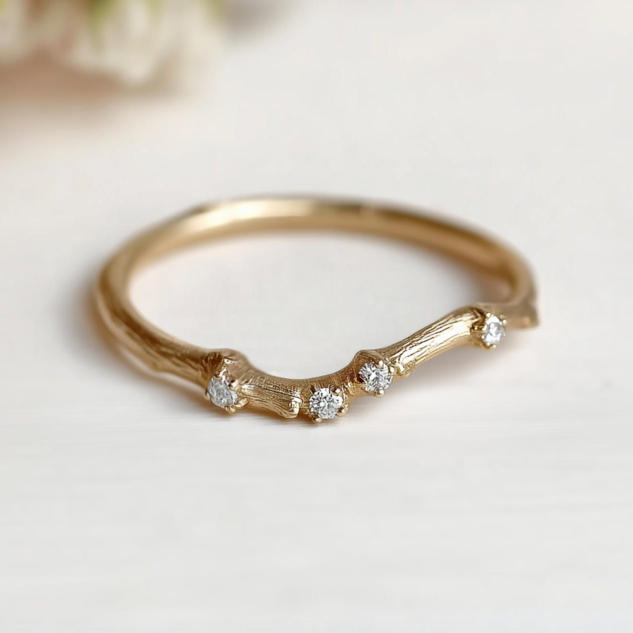 Gold ring with diamond accents on a light background