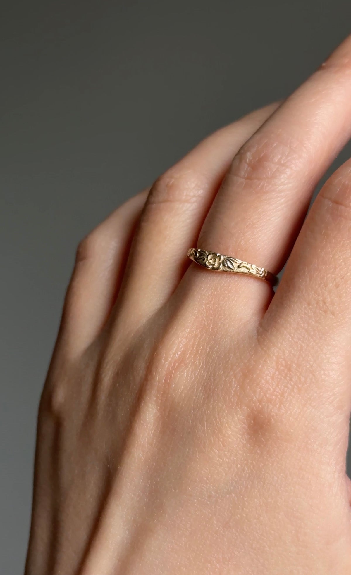 Nature inspired gold wedding ring shown on hand