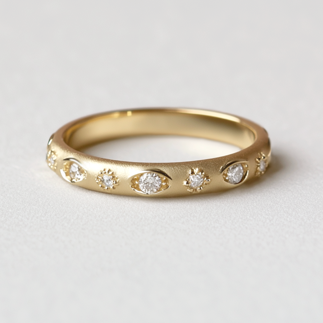 Gold ring with embedded diamonds on a light gray background