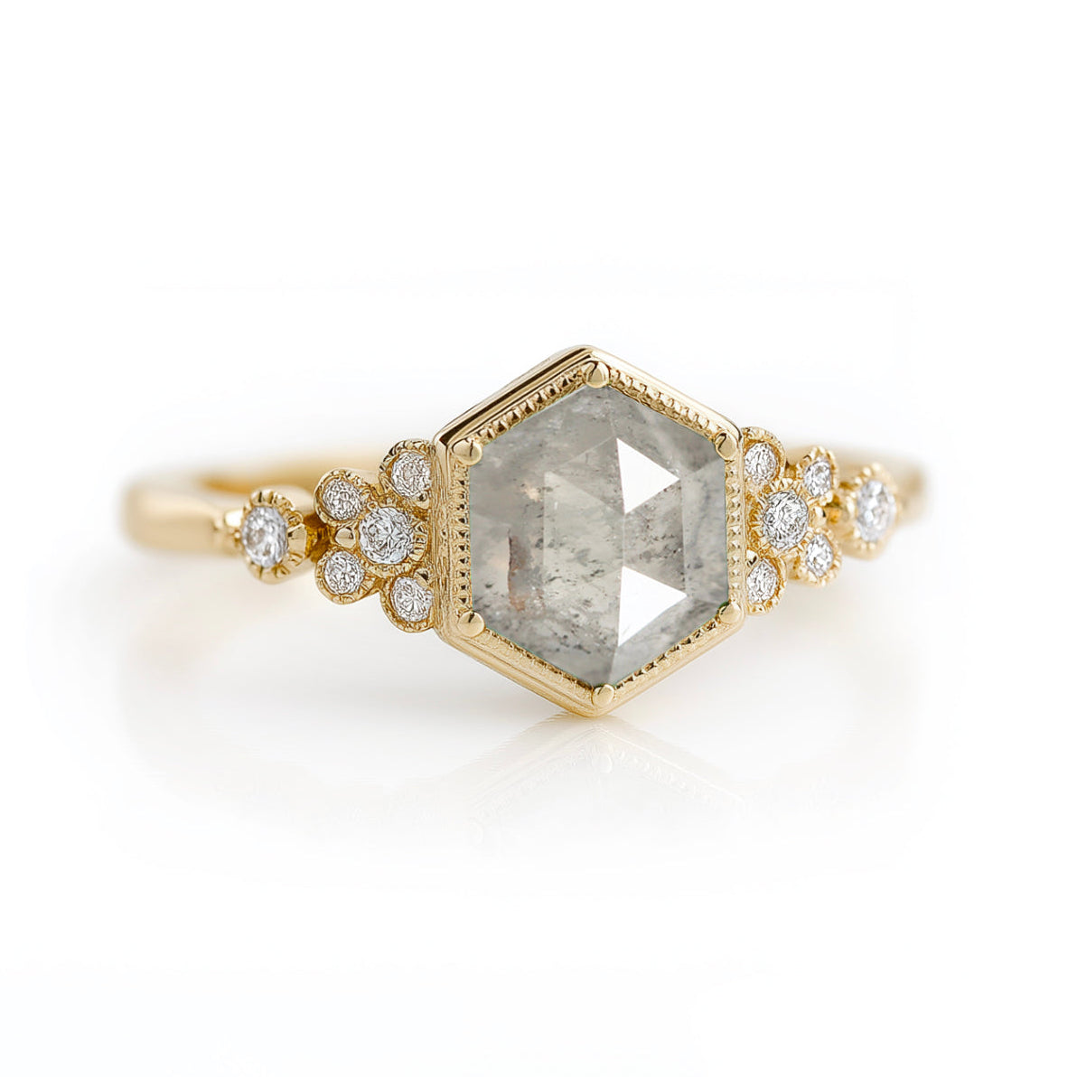 Gold ring with a hexagonal gemstone and diamond accents on a white background