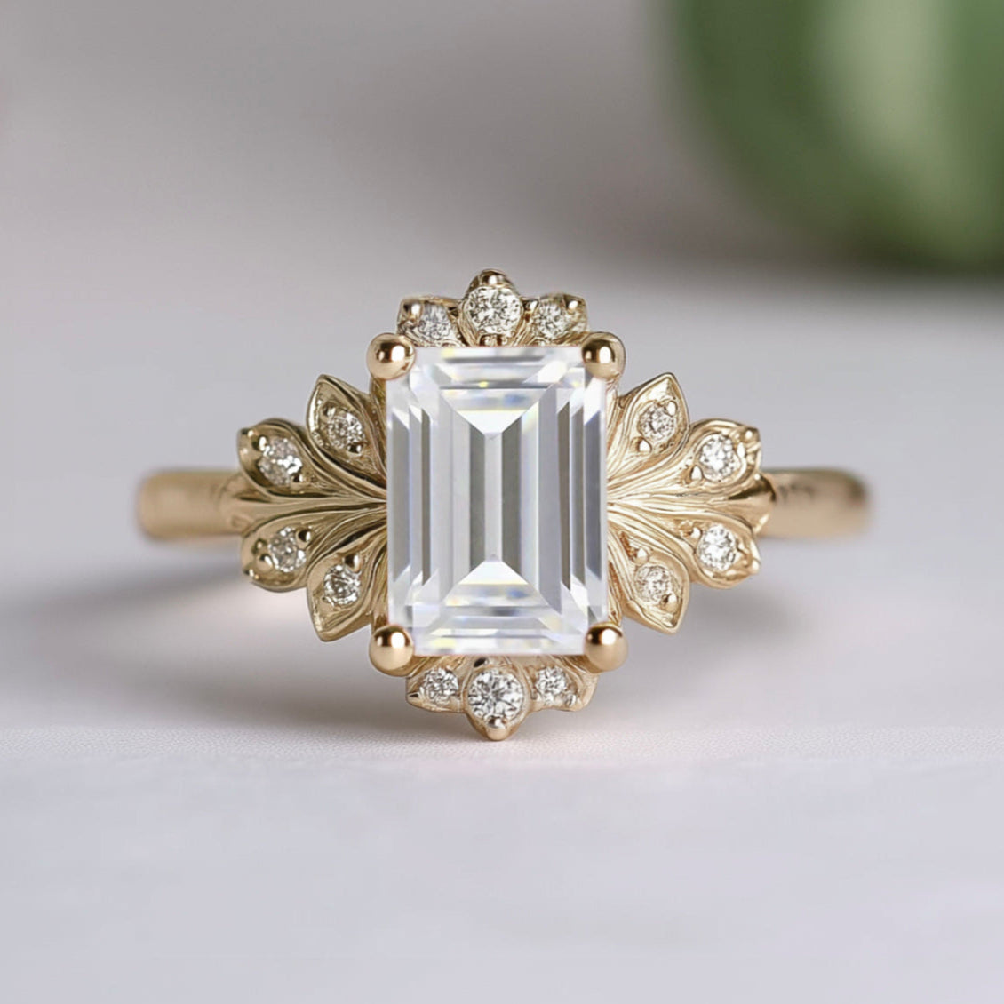 Gold ring with a large rectangular diamond and smaller diamonds on a light background