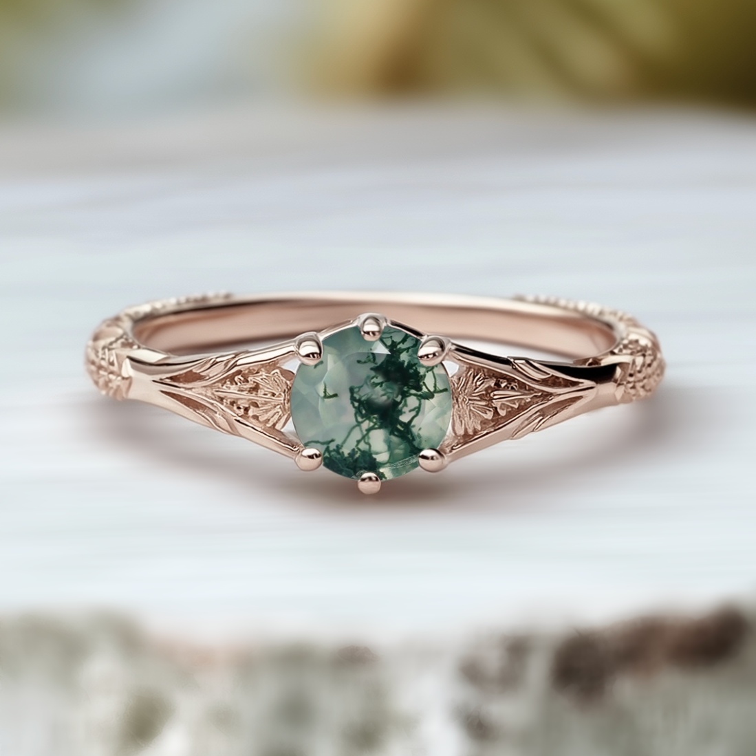 Rose gold ring with a green gemstone on a soft background