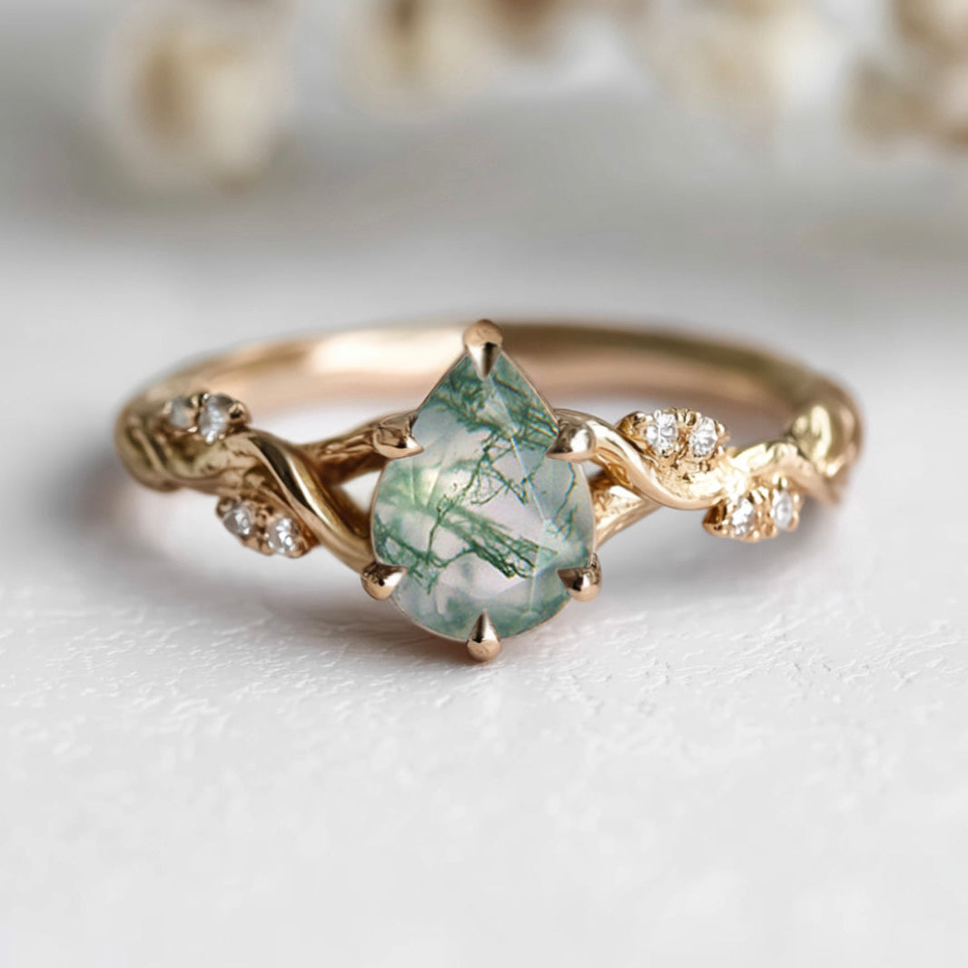Gold ring with a green gemstone on a light background