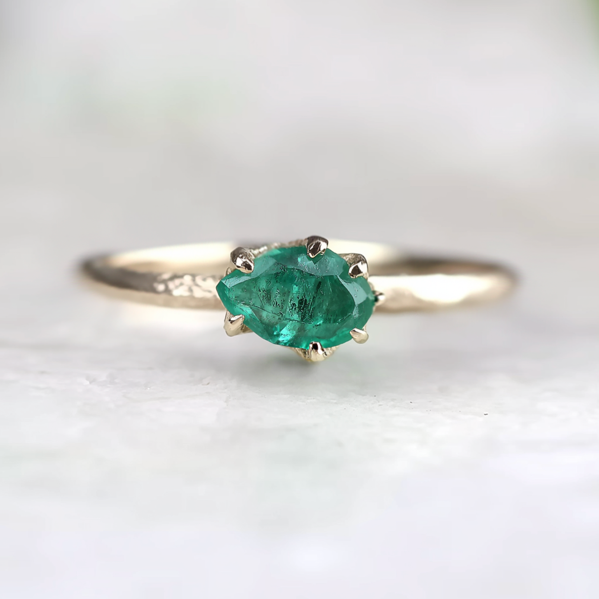 Ring with a green gemstone on a white background
