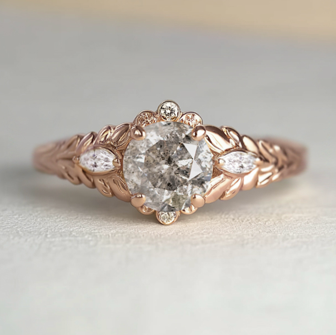 Rose gold ring with a diamond on a light gray background