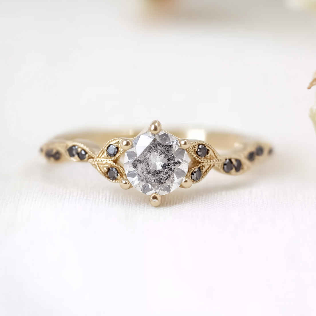 Gold ring with a diamond and smaller stones on a white background