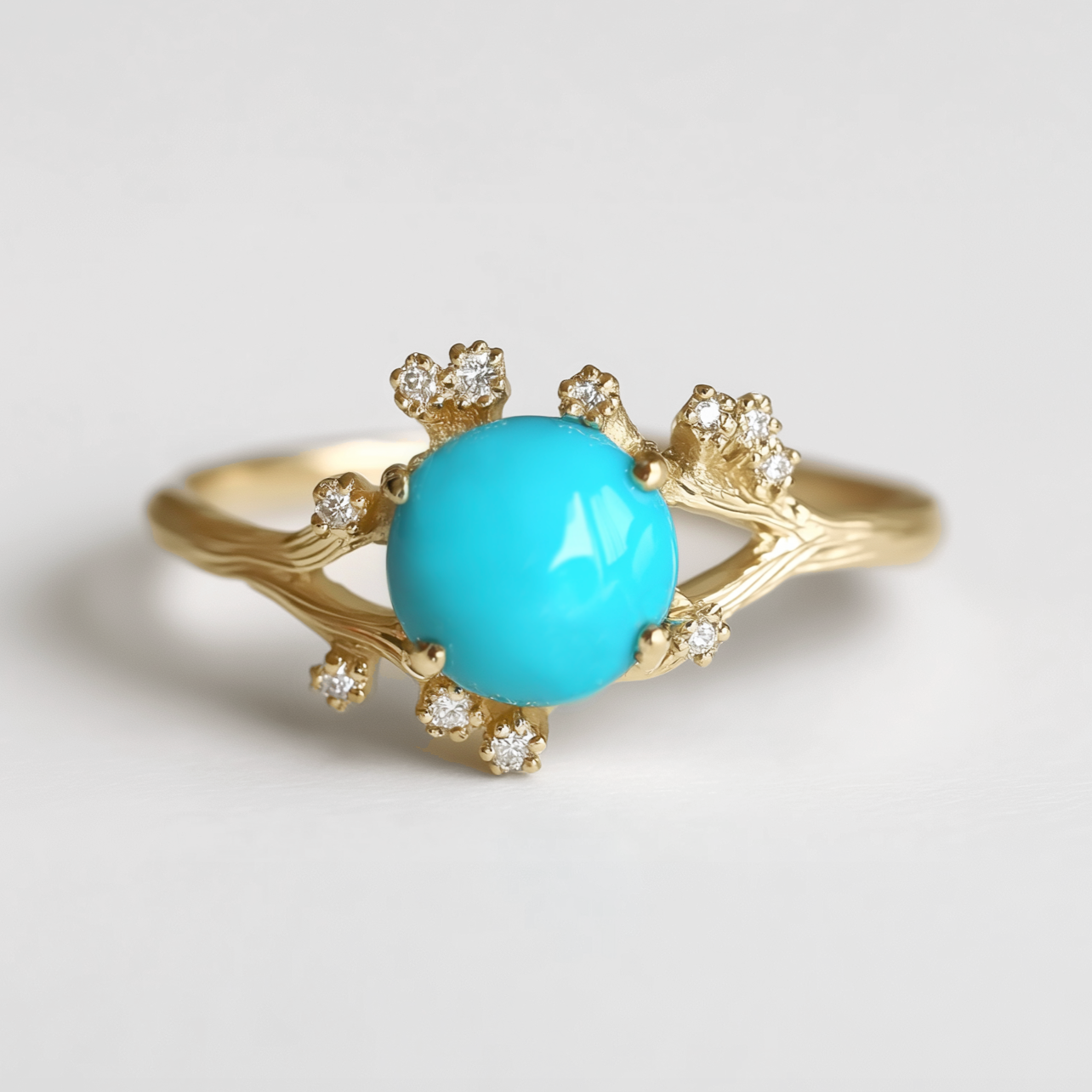 Gold ring with a turquoise gemstone and small diamonds on a light gray background