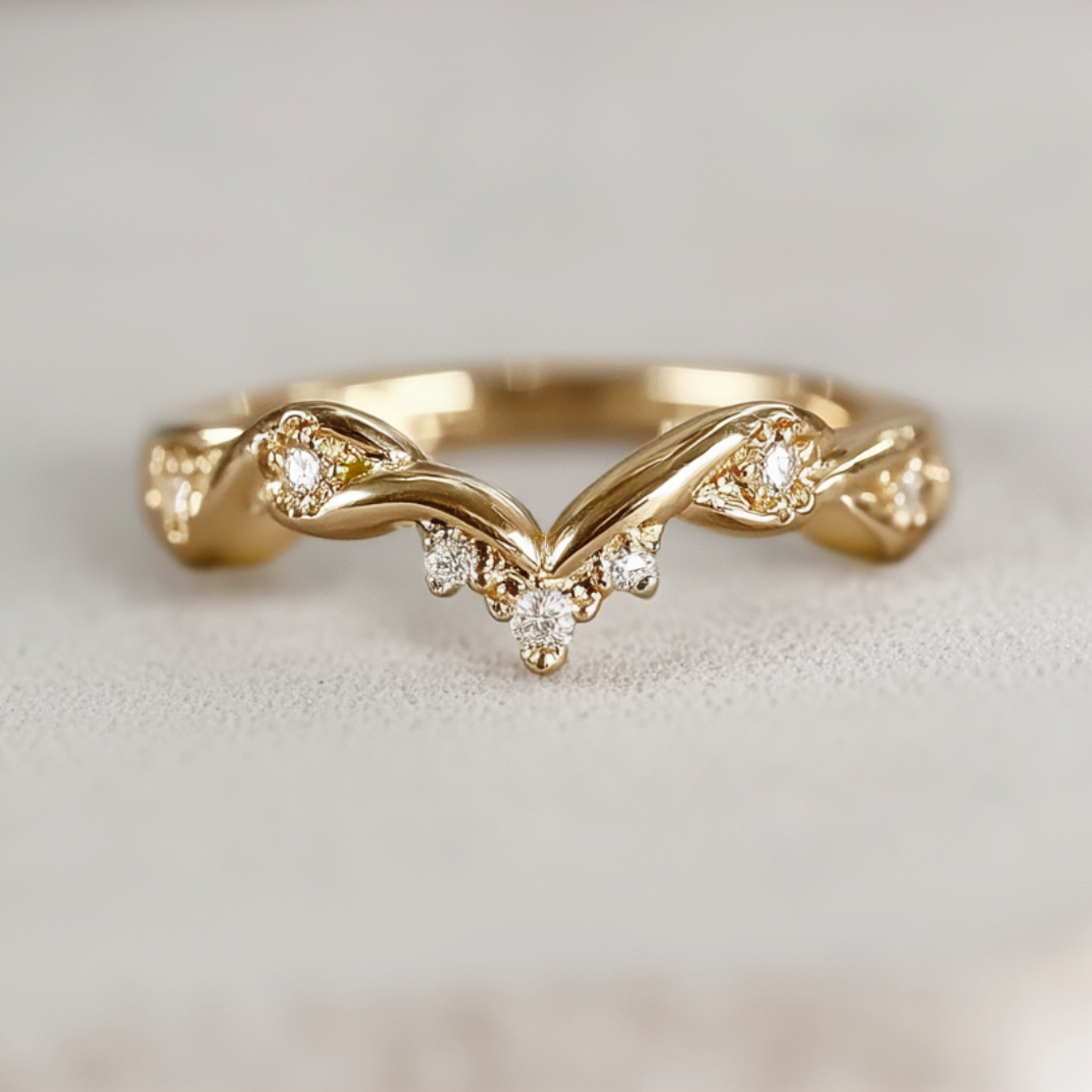 Gold ring with diamond accents on a light gray background