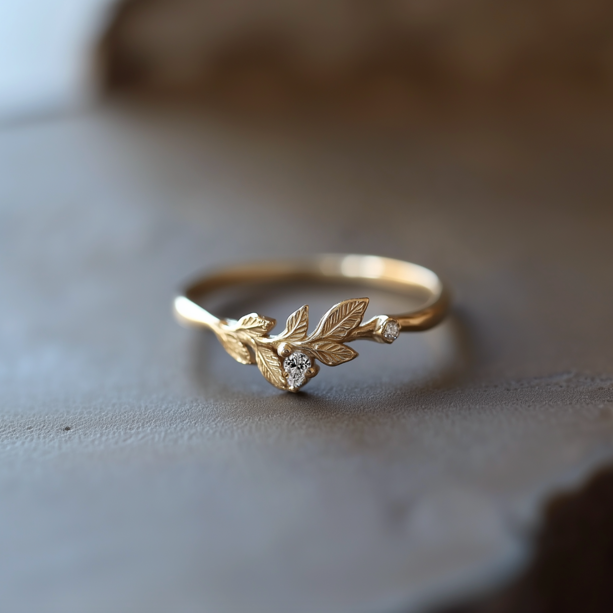 Gold ring with leaf design on a textured surface