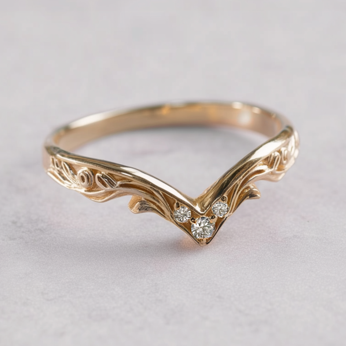 Gold ring with diamond accents on a light gray background