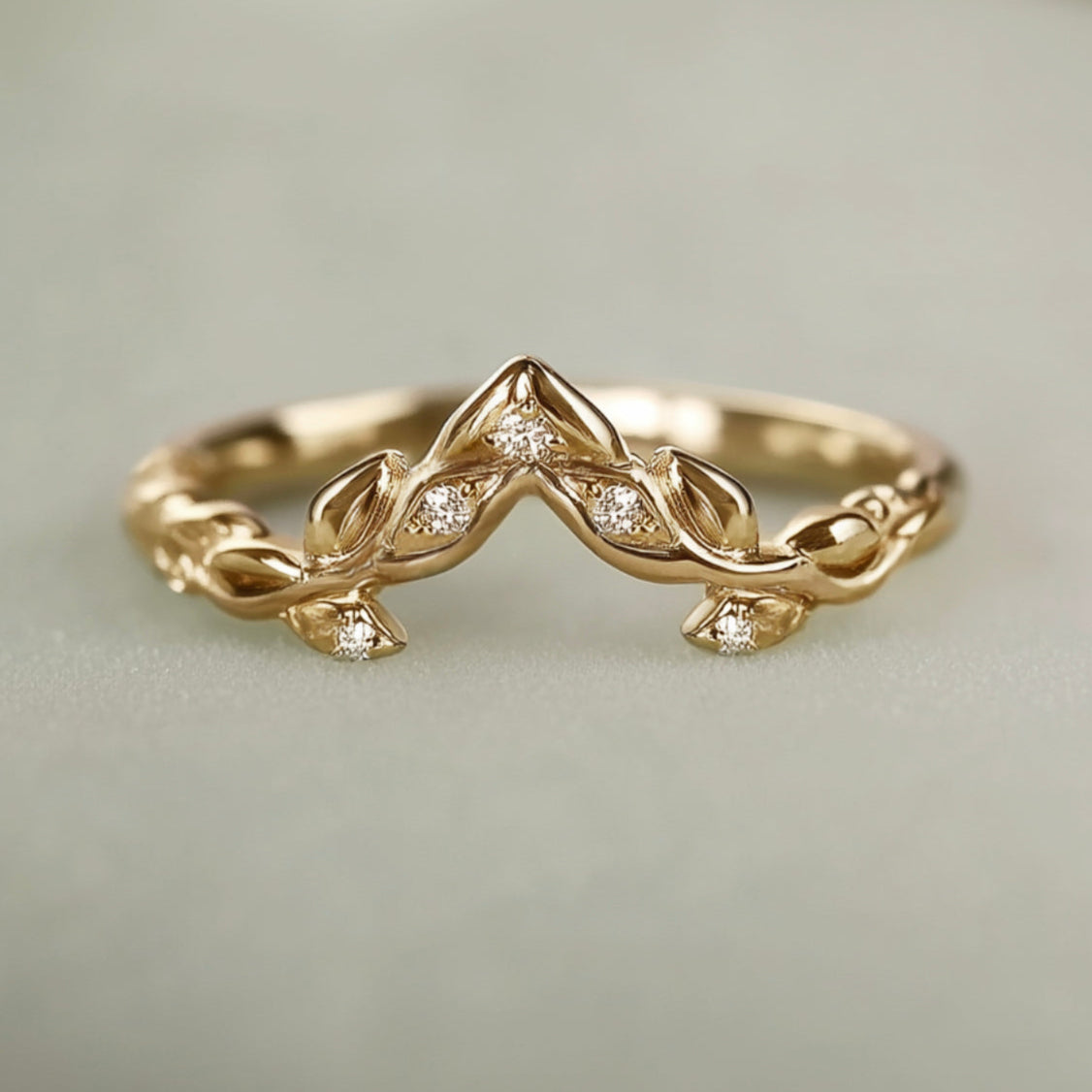 Gold ring with diamond accents on a light gray background